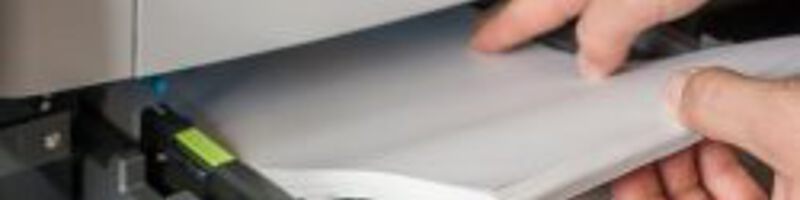 Kopierpapier_AdobeStock_125146834 Person gibt neues Papier in den Drucker