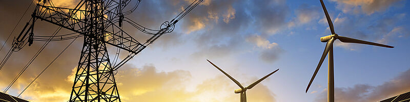 Windräder und Solaranlage während dem Sonnenuntergang