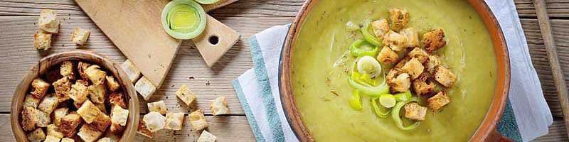 Suppe im Topf mit Brotstücken darin