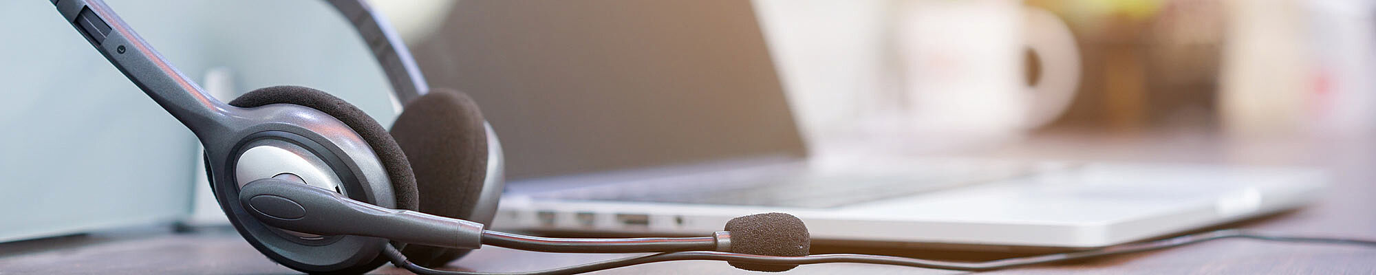 Laptop neben dem ein Headset liegt